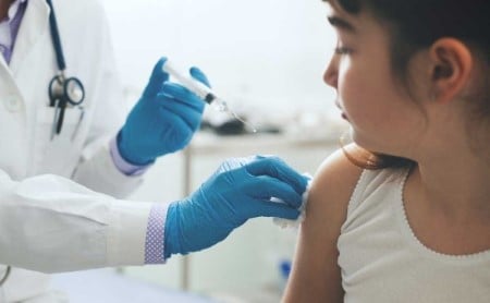 Healthcare worker giving a vaccine injection to a young girl