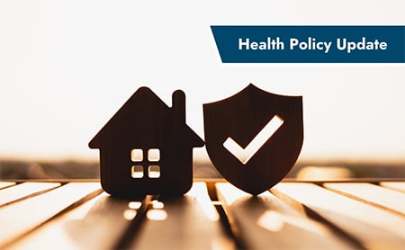 Wooden blocks in the shape of a house and a shield balance on a picnic table. ASTHO Health Policy Update banner in upper right