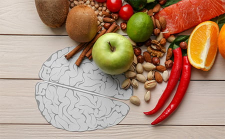 Healthy foods on a picnic table, which has a greyscale illustration of a brain on it