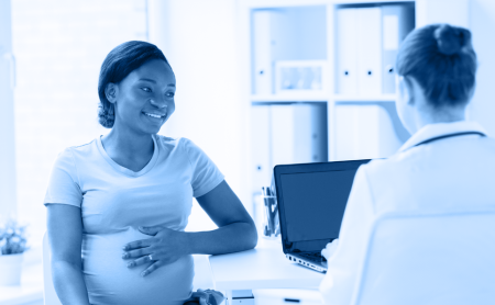 A pregnant woman talks with her doctor during an appointment, blue wash over image