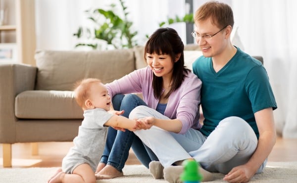 Happy parents playing at home with baby