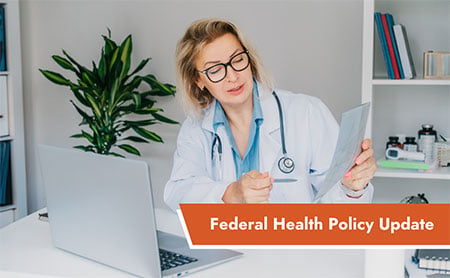 A doctor seated at a desk with a laptop, holding a document, with the text “Federal Health Policy Update” in the lower left.