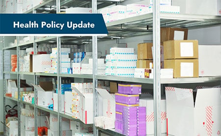 A storage room with shelves stocked with medical supplies and boxes, with the text “Health Policy Update” at the top.